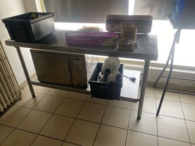 une table de cuisine sur laquelle se trouvent un micro-ondes et un lave-vaisselle