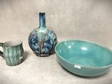 un bol bleu et un vase bleu posés l'un à côté de l'autre