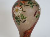 a vase that has a bird and flowers on it