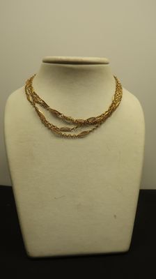 collier à chaîne en or présenté sur un mannequin, sur fond blanc