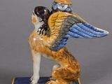 a figurine of a dog with a bird on its back