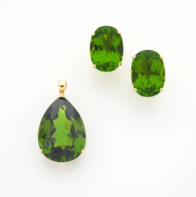 un gros plan sur une paire de boucles d'oreilles vertes et un pendentif
