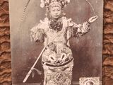 an old photo of a woman in a costume holding a sword