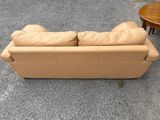 beige leather couch and loveseat in a parking lot