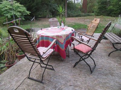 une table et des chaises sur une terrasse, recouverte d'une nappe