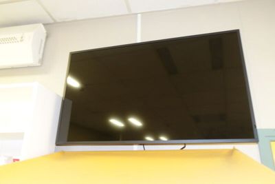 une télévision à écran plat posée sur une table jaune