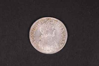 gros plan d'une pièce de monnaie en argent sur une surface noire