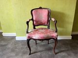 une chaise dont l'assise est rembourrée de tissu rose