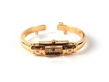 a close up of a gold bracelet with a clock on it