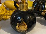 a black and gold perfume bottle sitting on a table