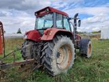 un tracteur rouge garé dans l'herbe