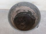 a dirty bucket sitting on the floor next to a white wall