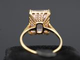 a gold ring with a white diamond in the center