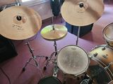 a drum set up in a room with a window in the background