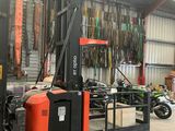 a forklift in a warehouse with a lot of tools hanging on the wall