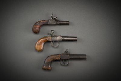 three old revolvers on a black background