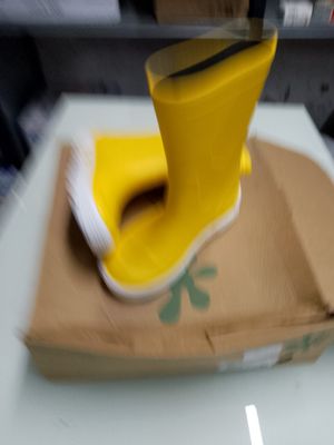 une chaussure jaune posée sur une boîte en carton