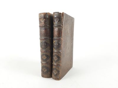 an old pair of books sitting next to each other on a white surface