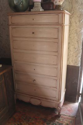 a dresser in the corner of a room with a vase on top of it
