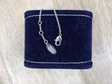 a close up of a blue velvet purse with a silver necklace on it