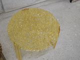 a glass table with a yellow top on the floor
