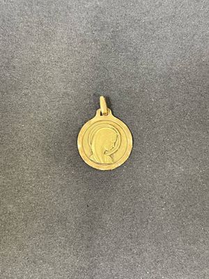 un gros plan d'une médaille d'or posée sur une surface grise