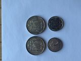 four different coins sitting on top of a piece of paper on a table