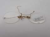 pair of clear glasses with gold rims on a white surface