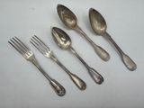 five silver spoons and two forks are lined up on a white surface