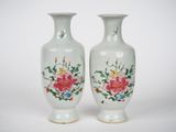 deux vases sur lesquels sont peints des fleurs sur fond blanc