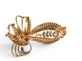 a gold brooch on a white background with a ring