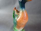 a colorful duck figurine sitting on a gray surface