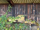 an old wheelbarrow in front of an old barn