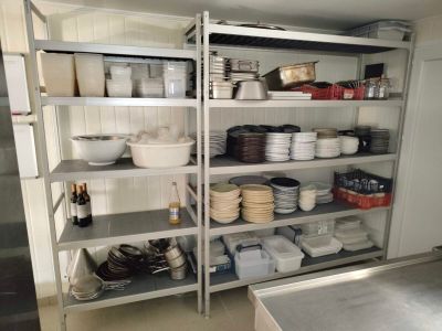 de nombreux plats et bols sur les étagères de la cuisine