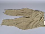 pair of tan pants with zippers on a white surface