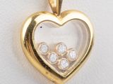 an image of a gold heart shaped pendant with diamonds in it