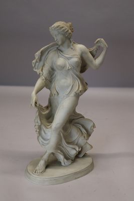 une statue de femme tenant un oiseau dans sa main