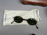 a pair of sunglasses sitting on a bag next to a pair of glasses