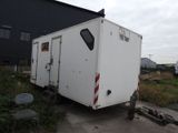 a white trailer that is parked in front of a building