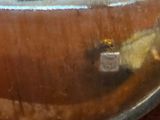a close up of a silver spoon with a black cross on it