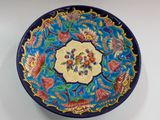 a blue and yellow plate with a floral design on it