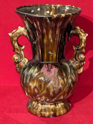 un vase posé sur une surface rouge