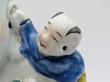 a figurine of a man and a child sitting on a snowman