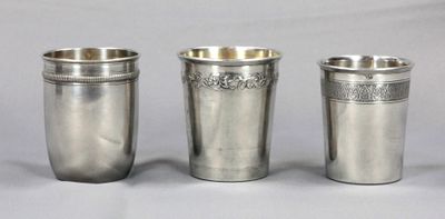 trois coupes en argent posées les unes à côté des autres sur une table