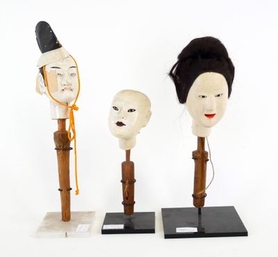 trois têtes de mannequin et un socle en bois représentant un visage de femme