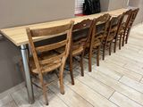 several wooden chairs are lined up at a table in a restaurant
