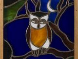 an image of a stained glass owl sitting on a tree branch