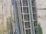 une pile d'échelles appuyées contre un mur en béton