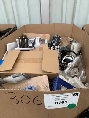 une boîte en carton remplie d'appareils électroniques posée par terre