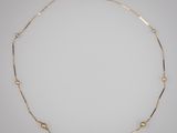 un collier en or orné de perles sur fond blanc